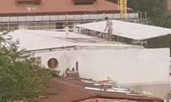Çocukla birlikte çatıda halı yıkayan vatandaş kamerada
