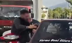 Otomobil sürücüsü dışarıya çıkmayınca motosikletli camdan içeri girmeye çalıştı