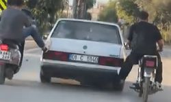 Motosikletliler, yolda kalan otomobili ayaklarıyla ittirdi