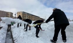 Yüksekova'da 20 kişilik ekibin çatıda kar temizleme mesaisi