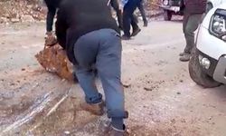 Yola düşen kayaları iple araca bağlayıp çektiler