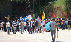 1 Mayıs kutlamalarında yürüyen işçilerle çalışan işçiler aynı karede