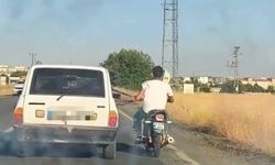 Otoyolda tehlikeli yolculuk: Motosiklet, otomobil kemerine tutunarak ilerledi