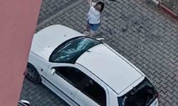 Park halindeki otomobilin camlarını kıran kadın kamerada