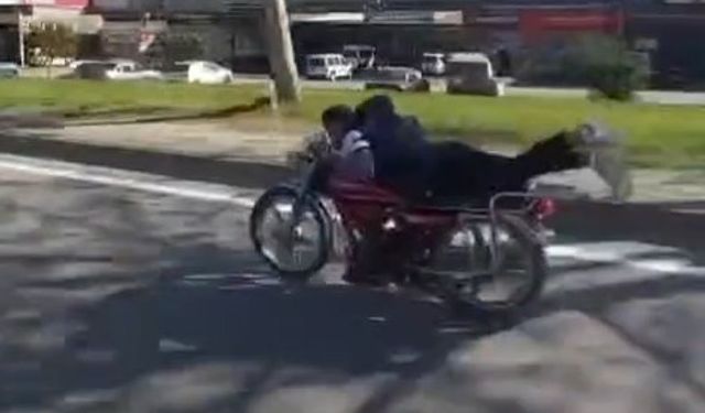 Plakasız motosiklet sürücüsü ellerini bırakıp motorun üzerine yatarak ilerledi